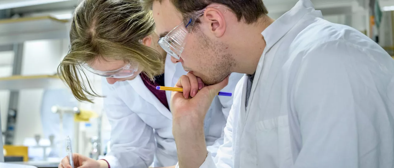 Students writing and contemplating something during a lab session