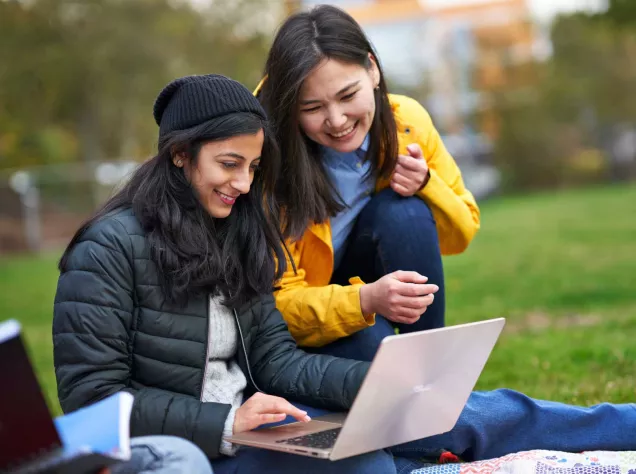 Smiling students looking at computer
