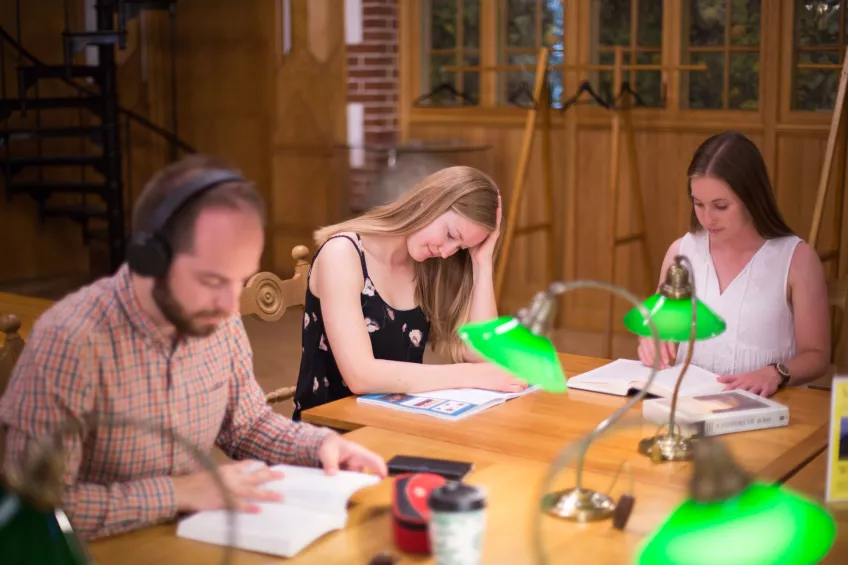 Three students studying in one of the quiet rooms at the University Library